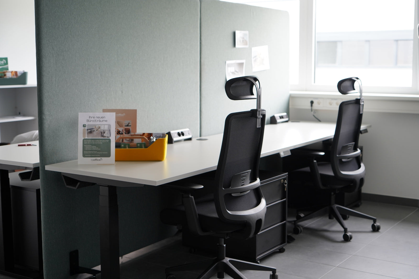 Musterbüro Flexipark: zwei Arbeitsplätze mit höhenverstellbaren Schreibtischen, Akustik-Trennwänden und ergonomischen Drehstühlen