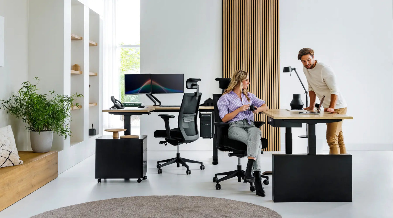 Modern eingerichtetes Büro mit höhenverstellbaren Schreibtischen, ergonomischen Drehstühlen und Rollcontainern